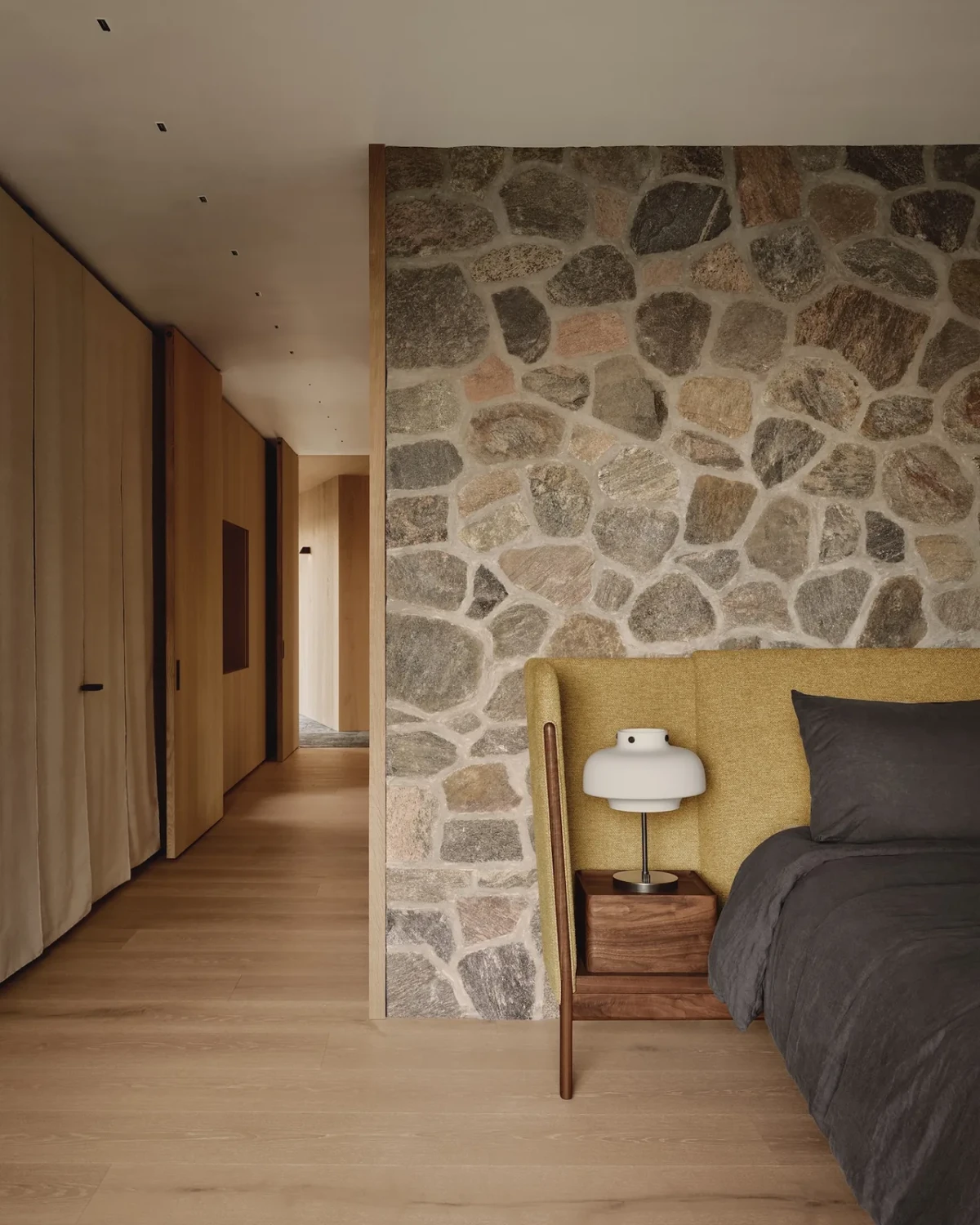 卧室以原生石材获得安定感 / Fieldstone gives the bedroom a grounded calm